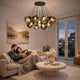 s.luce Orb Cluster Glas-Pendelleuchte 13-flammig 13x20cm im modernen Wohnzimmer über Sofa, elegante Lichtwirkung, ideal für entspannte Abende.
