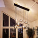 s.luce Orb glass ball pendant light in a modern space with large windows and plants.
