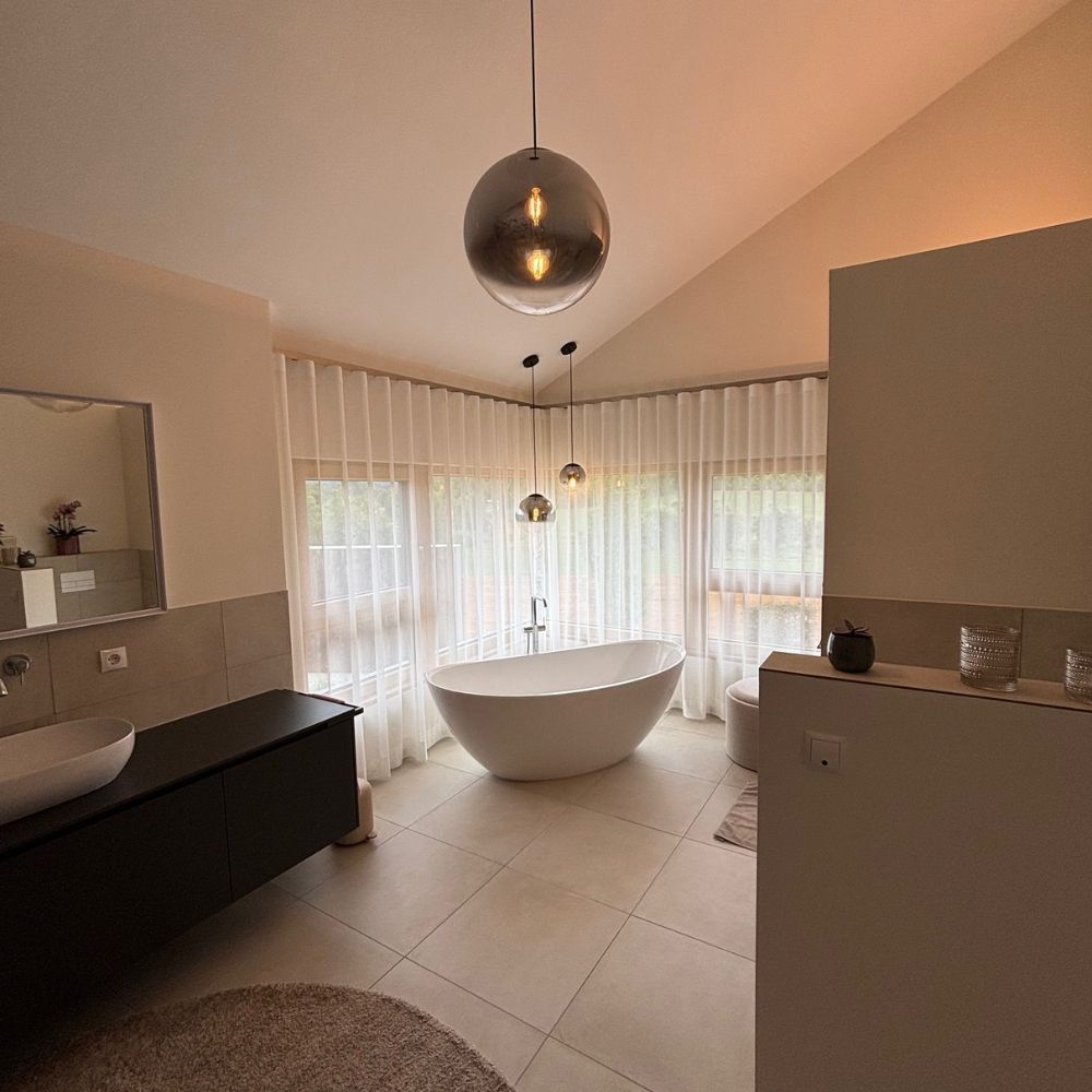 s.luce Orb glass ball pendant light in a stylish bathroom with bathtub and bright window.