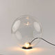 s.luce Orb Glaskugel Tischlampe in minimalistischem Design mit transparentem Globus und schwarzem Metallring.