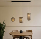 s.luce Velo 3-flammige Pendelleuchte über Esstisch mit modernem Design und flexibler Glaslampe.