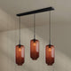 s.luce Velo Esstisch-Pendelleuchte 3-flammig 120cm Ø 18cm in elegantem Design mit runden, braunen Glasleuchten.