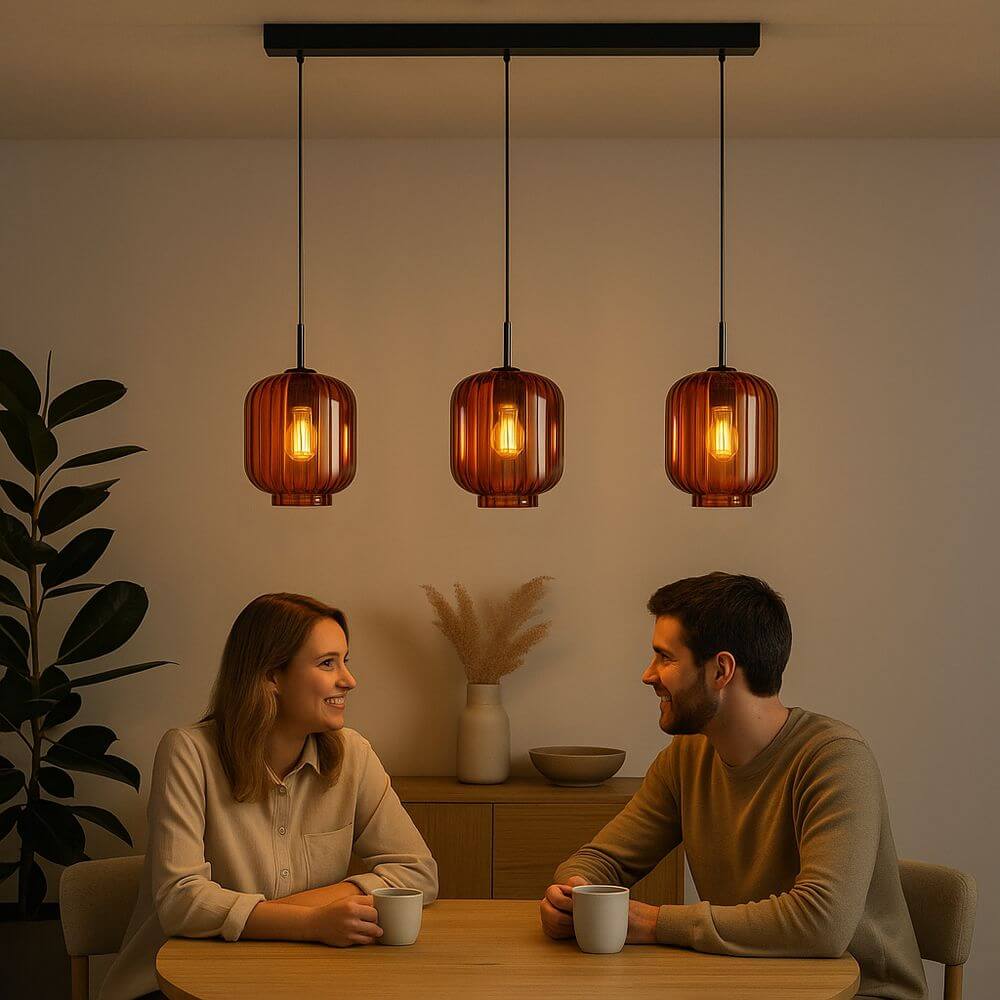 s.luce Velo Esstischlampe 3-flammig Baldachin 120cm Ø 20cm über einem modernen Esstisch mit zwei Personen.