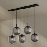 s.luce Velo Esstischlampe 5-flammig 160cm Baldachin Ø 20cm mit stilvollen Glasleuchten über einem Esstisch.