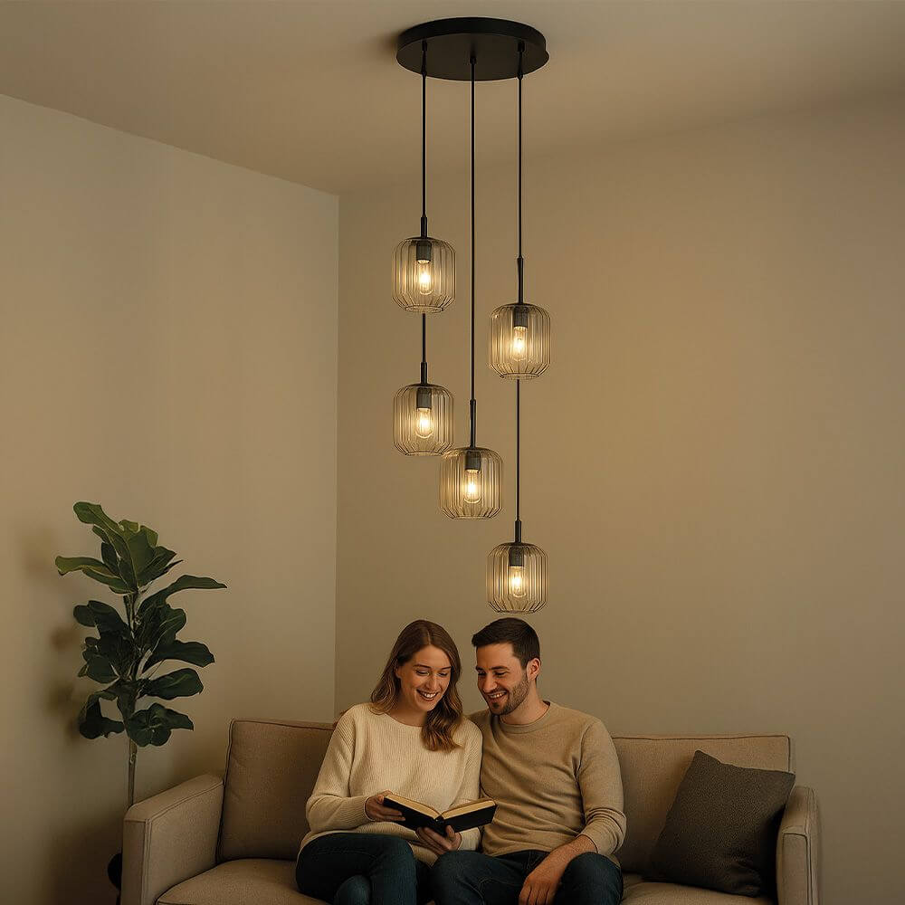 s.luce Velo 5-flammige Galerieleuchte in Wohnbereich über Sofa mit Paar, elegant und modern.
