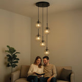 s.luce Velo 5-flammige Galerieleuchte in Wohnbereich über Sofa mit Paar, elegant und modern.