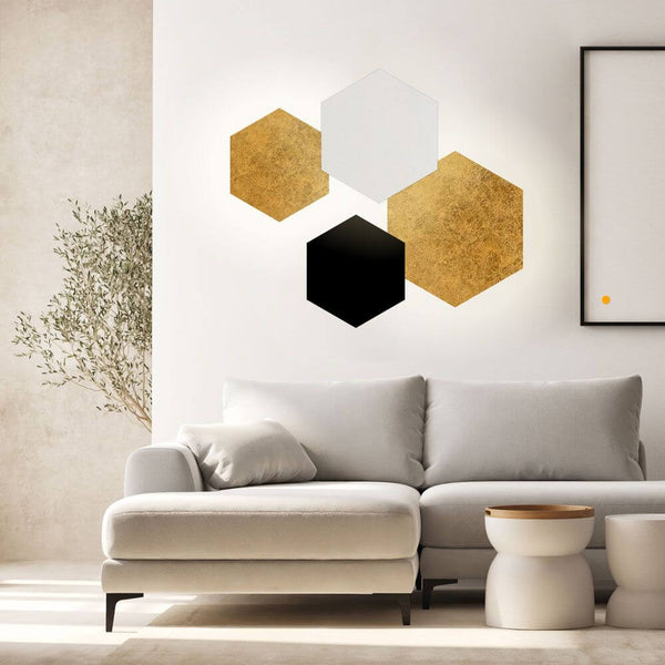 s.luce Applique murale Hive a illuminazione indiretta LED in vari colori sopra un divano moderno.