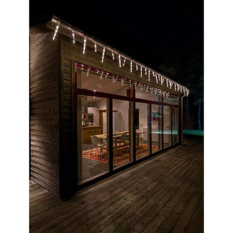 LED Icicle light curtain 32 drops with multifunction 96 warm white diodes IP44 on a wooden house at night.