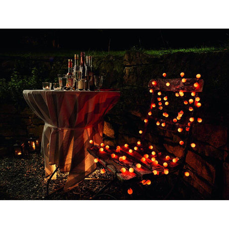 LED Globe string lights large round diodes with RGB color change 80 RGB diodes IP44 on a table and chair in the garden