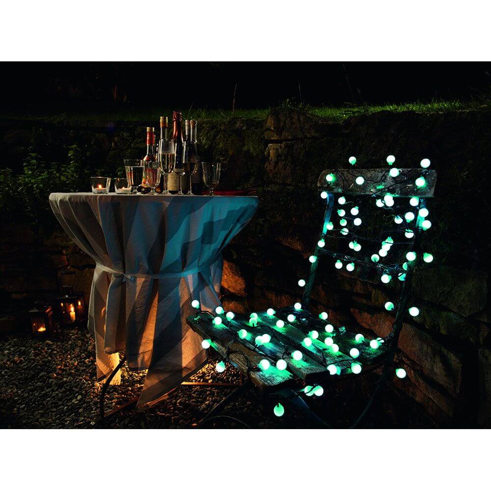 LED Globelichterkette große runde Dioden mit RGB Farbwechsel 80 RGB Dioden IP44 auf einem Tisch und Stuhl im Garten bei Nacht.