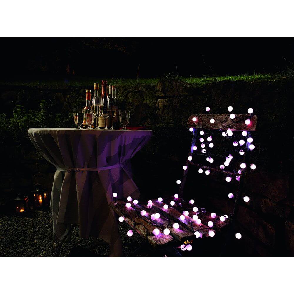 LED Globelichterkette große runde Dioden mit RGB Farbwechsel 80 RGB Dioden IP44 auf einem Tisch und Stuhl im Garten.
