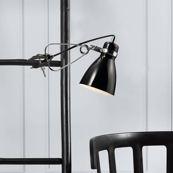 Cyclone clip-on lamp black mounted on a shelf, ideal for modern, minimalist design.