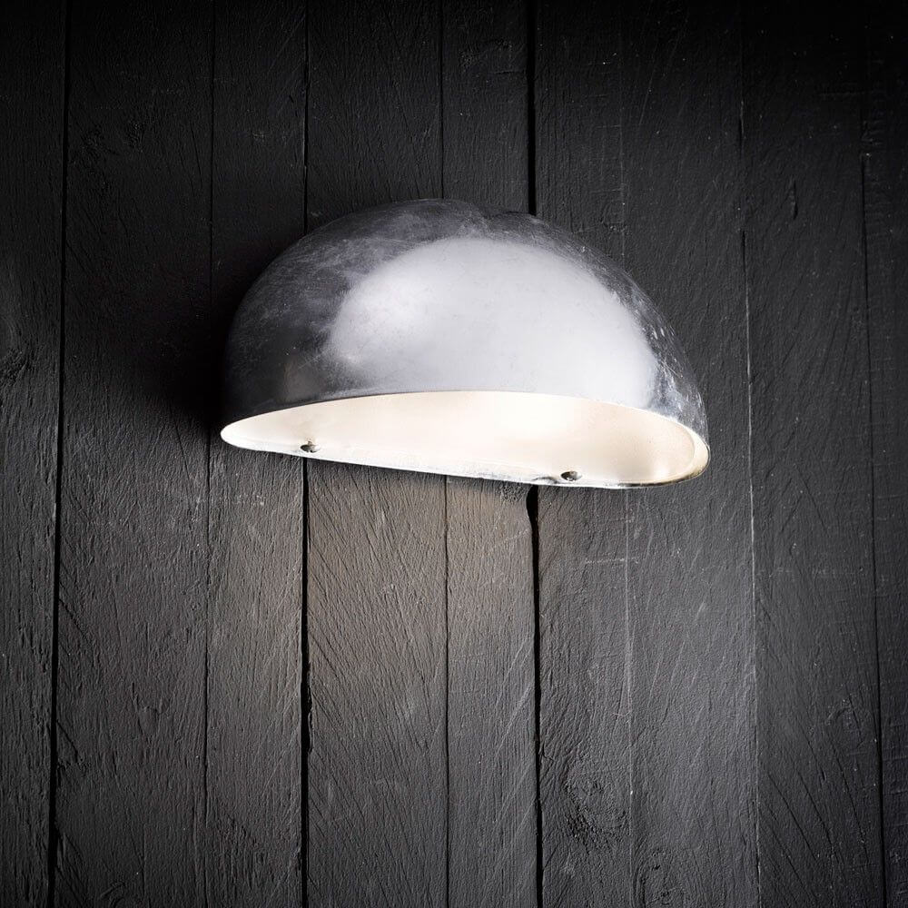 Scorpius Außen Wandleuchte aus Zink, modern, robust, auf schwarzem Holzuntergrund, ideal für Innen- und Außenbereiche.