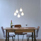 Drop-2XS LED 5er-Hängeleuchte Liquid-Light Weiß über einem Tisch mit Wein und Gläsern.
