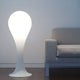 Drop-4L Stehleuchte 100cm Liquid-Light Weiß neben einem modernen Sofa in einem minimalistischen Raum.