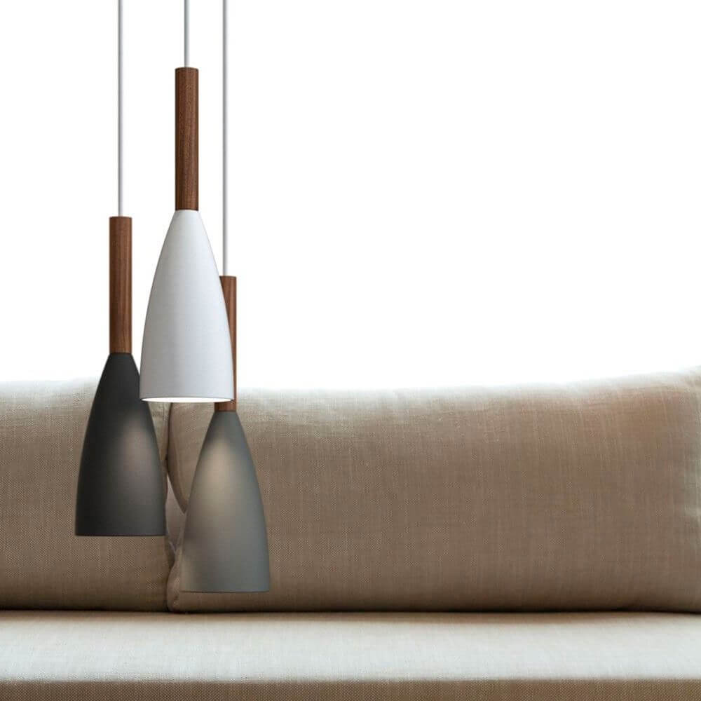 Pendelleuchte Pure Schwarz, Walnuss über einem stilvollen Sofa in neutralen Farben.