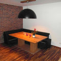 s.luce Blister Pendelleuchte 70cm in Schwarz über einem Holztisch in modernem Esszimmer mit Backsteinwand.
