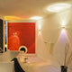 Moderne Badezimmeransicht mit roter Wand, eleganten Lichtern und entspannender Atmosphäre.